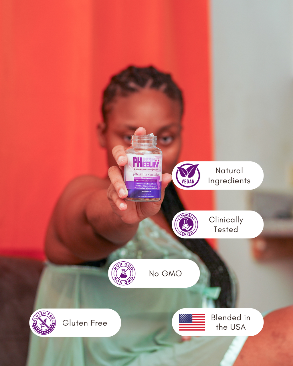 Person holding a bottle labeled pHertility Capsules with certification icons on a blurred background